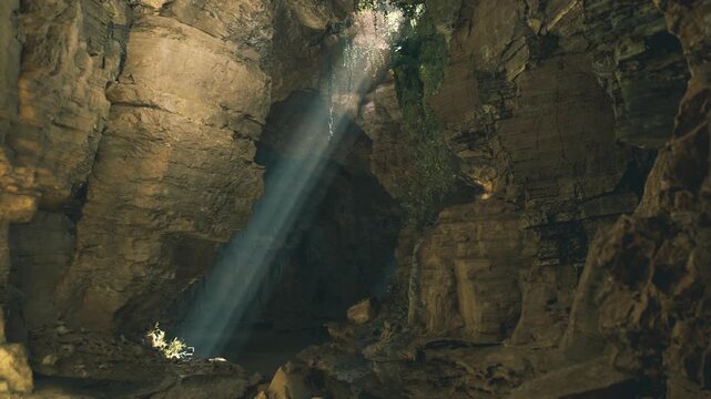 Photographer composition mammoth cave system capturing angled sunbeams across textured rock, high contrast pockets of shadow and warm earthy palette ideal