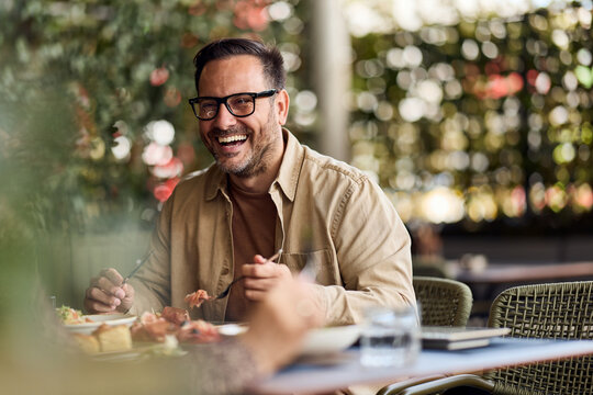 Happy Man Laughing Over Brunch at Outdoor Cafe &mdash; Casual Business Lunch and Social Gathering