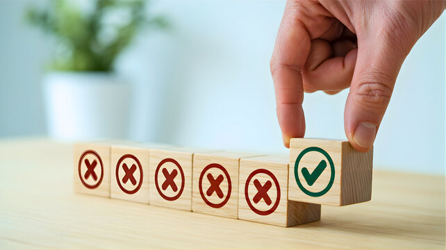 Hand placing a wooden block with a green checkmark among red 'X' blocks, symbolizing the correct choice, positive decision, successful outcome, or validated solution in any endeavor