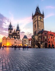 Obraz premium Stone buildings, church spires, and a clock tower in a city square