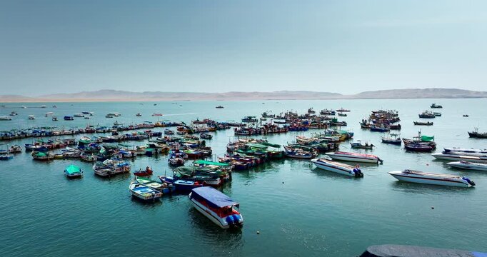 Aerial of fishing boats anchored in Paracas Bay along the Pacific coast of Peru, medium tracking right