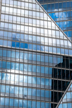 Geometric glass facade with diagonal bracing and clouds architecture facade office corporate urban abstract glass pattern modern district reflection