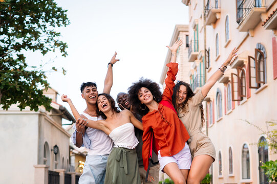 Diverse group of friends celebrates joy and togetherness while traveling, expressing pure happiness
