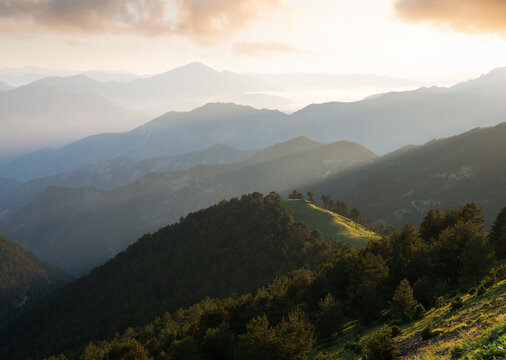 Beautiful views of the mountain foggy ranges. Misty peaks and sunset silhouettes.