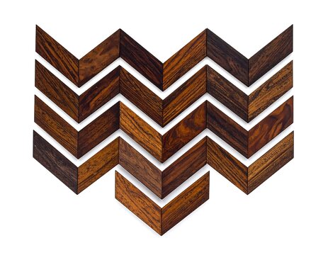 Wooden chevron pattern on white background. Multiple segments form an interesting zig-zag arrangement. Light & dark wood contrast is evident