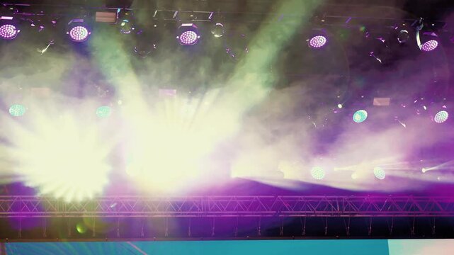 Stage Lighting Setup with Colorful Spotlights and Fog Effects in Event Venue