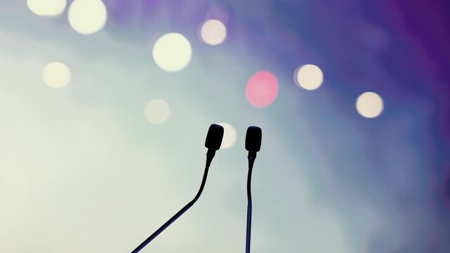Dual Conference Microphones on Podium with Blurred Audience Background