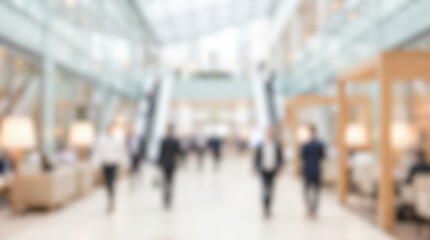 Obraz premium Blurred abstract background modern bright large corporate office business center mall interior walking people silhouettes daylight illuminated spacious architectural hall design empty