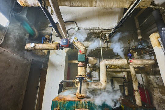 Steam leaking from old boiler room pipes