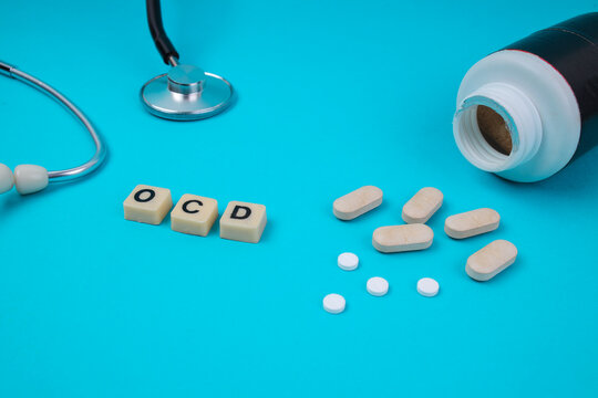 High Angle View Of OCD Word In Tiles With Stethoscope And Spilled Pills For Medical Treatment