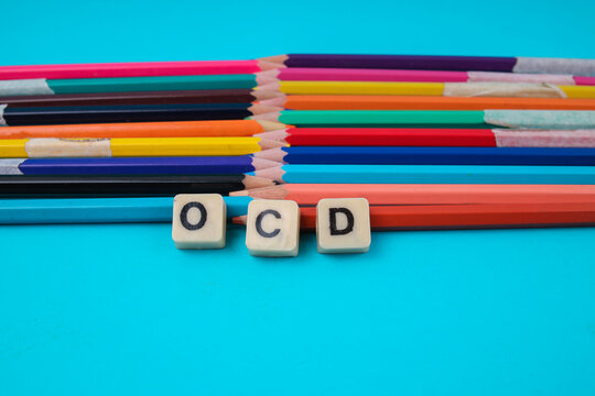 Close Up Of OCD Word In Tiles With Imperfect Colored Pencils For Mental Health Concept