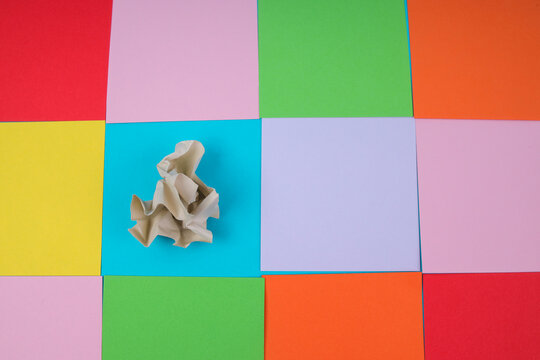 Top View Of Crumpled Paper On Colorful Square Grid Representing OCD And Imperfection