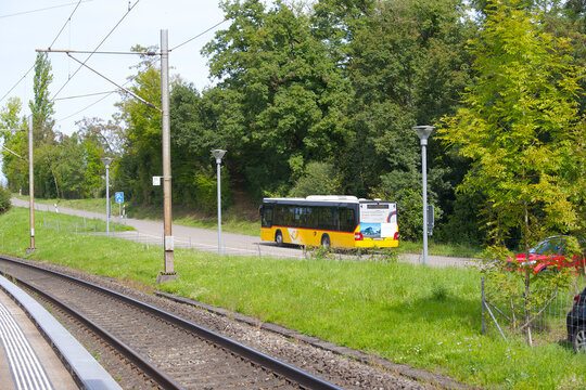 Yellow Swiss Post bus number 540 passing at railway station of Swiss village of Glattfelden on a sunny late summer day. Photo taken September 7th, 2025, Glattfelden, Switzerland.