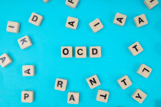 Top View Of OCD Word In Tiles Surrounded By Scattered Random Letters For Mental Health Concept