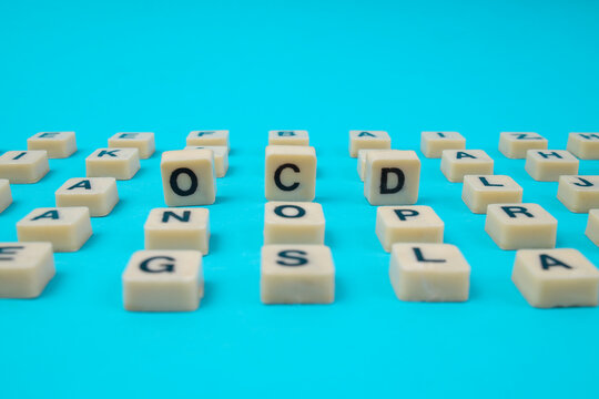 Low Angle View Of OCD Letter Tiles Standing Out From Flat Alphabet Grid For Mental Health Concept
