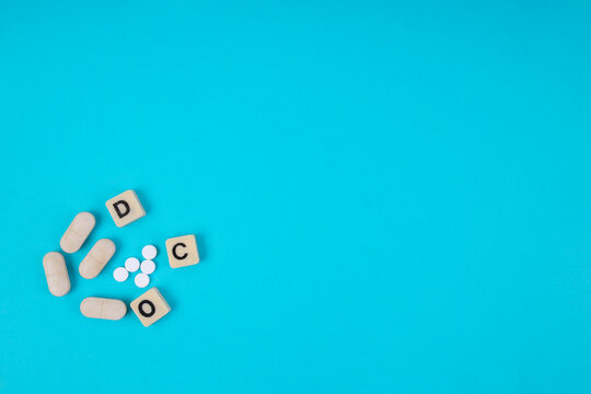 Top View Of Scattered OCD Letter Tiles And Pills On Blue Background With Copy Space For Mental Health Concept
