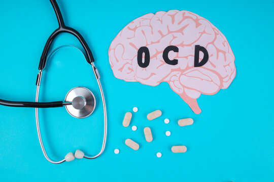 Top View Of Paper Brain With OCD Text Stethoscope And Pills For Mental Health Concept