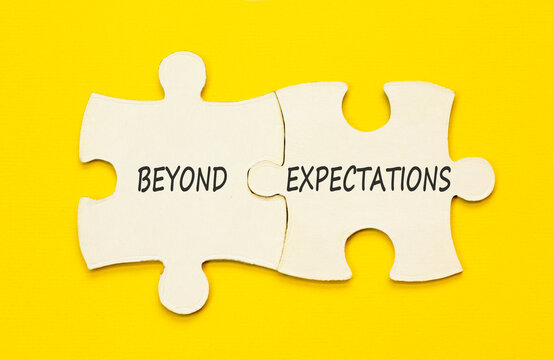 Beyond expectations words symbol. Concept words Beyond expectations on beautiful white puzzles. Beautiful yellow background. Business Beyond expectations words concept. Copy space.