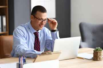 Obraz premium Male accountant working with laptop at table in office
