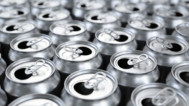 Rows of open soda cans on a factory floor during production time showing different angles and positions of the cans lined up neatly