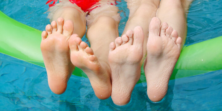 Children feet in a swimming pool