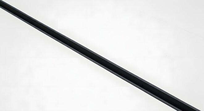 Long black metal profile for architectural finishing or drainage installed on clean white background for construction.