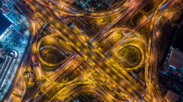 Aerial view of traffic on massive highway intersection at night.