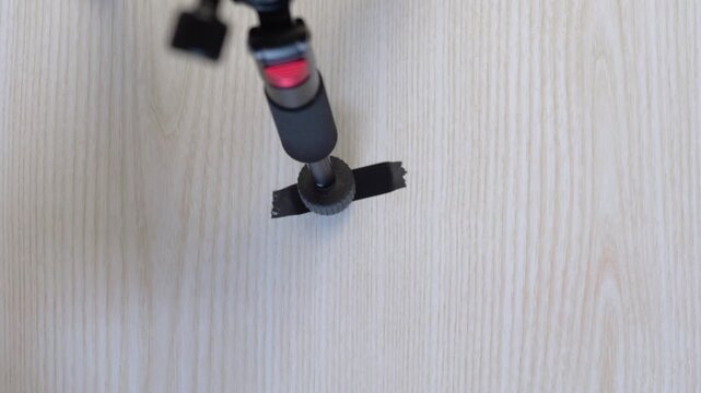 Hand attaching mount. Assembly process involving securing and leveling equipment properly. Finalizing setup by accurately fixing and aligning stand for stability and support
