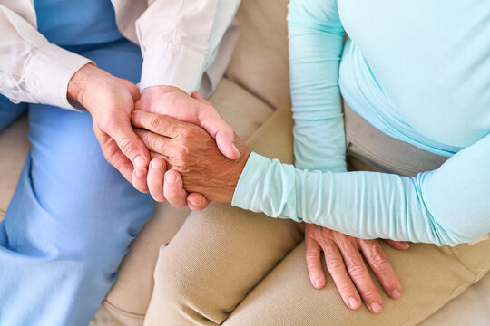 Senior Healthcare Support: Compassionate Nurse Holding Elderly Patient'S Hand, Offering Comfort And Medical Assistance