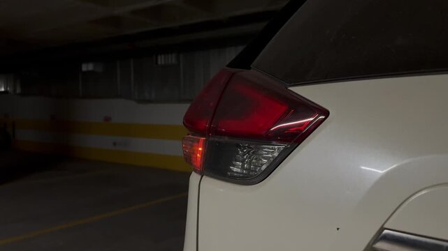 flashing red turn signal and hazard warning light on rear foot of headlight in black car. modern car, emergency stop