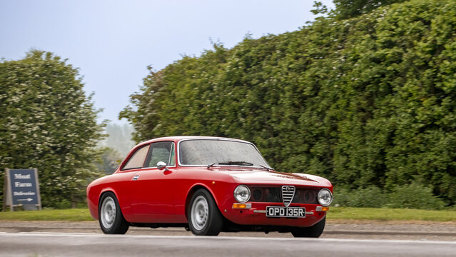 Bicester,Oxon.,UK - Apr 26th 2026:  1976 red Alfa Romeo gt junior car driving on a British road