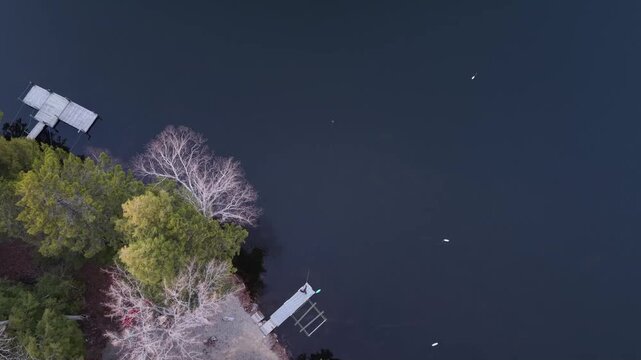 Drone straight down view of a man fishing from a dock on a calm evening