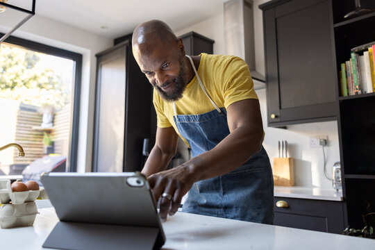 Mature man cooking in the Kitchen with a Tablet Device