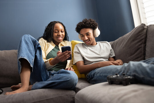 Teens Sharing a Laugh While Engaged on Phone