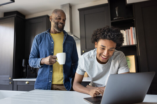 Father and son sharing a fun moment over a laptop