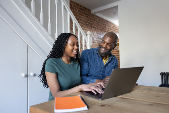 Daughter showing father his school grades on a laptop