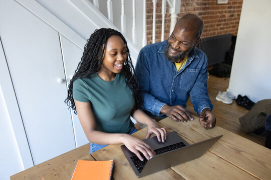 Father and daughter sharing a joyful learning moment at home