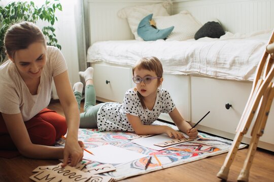 Mother assisting child with physical disability learning at home