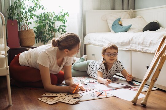 Mother and child learning together at home, disability support