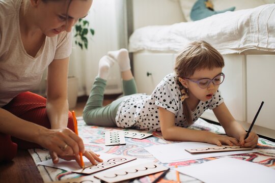 Mother assisting child with special needs learning at home