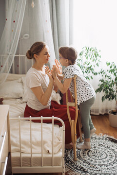 Mother and daughter with physical disability playing at home