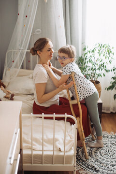 Mother supporting child with physical disability at home