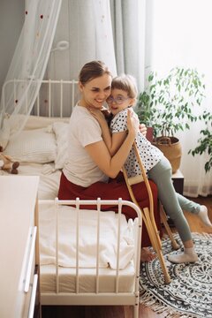Mother hugging child with disability at home