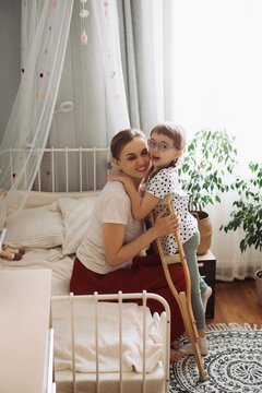 Mother and child with disability hugging, spending time home