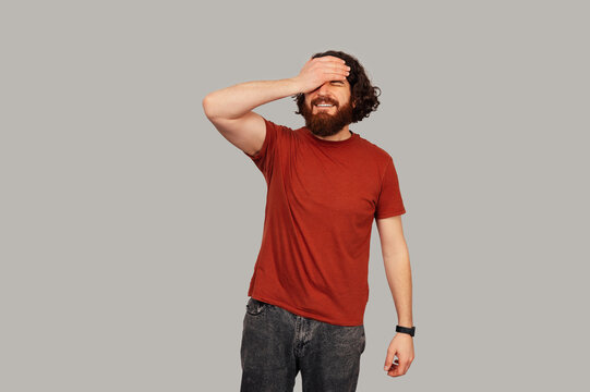 Caucasian Man Covering Eyes While Laughing, Playful Embarrassed Reaction, Studio Portrait With Red Shirt