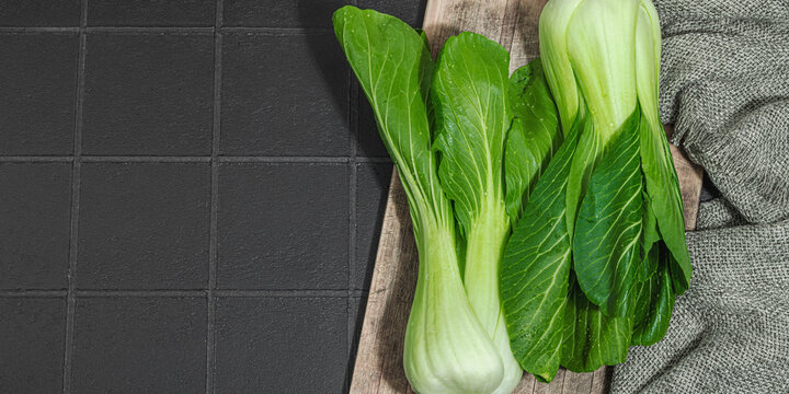 Fresh Bok choy on a trendy black tile background. Traditional Chinese cabbage vitamin ingredient