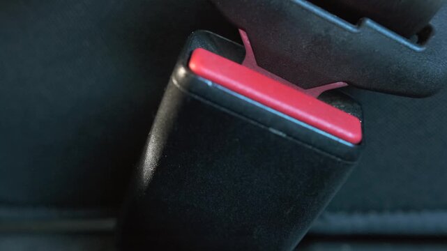Inside car inserting seat belt into buckle fastening process, safety system use. Locking click secures passenger, highlighting protection, compliance, driving safety, secure travel in vehicle interior