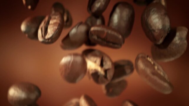 Super Slow Motion Macro of Coffee Beans Falling on Brown Cinematic Background at 1000fps.