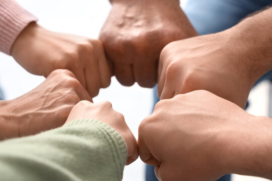 People bumping fists at group therapy session, closeup