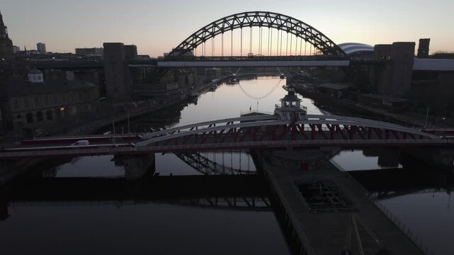Swing Bridge and the high arch of the Tyne Bridge in Newcastle , with the Millennium Bridge and the modern silhouette of The Glasshouse (Sage) visible in the soft morning light.